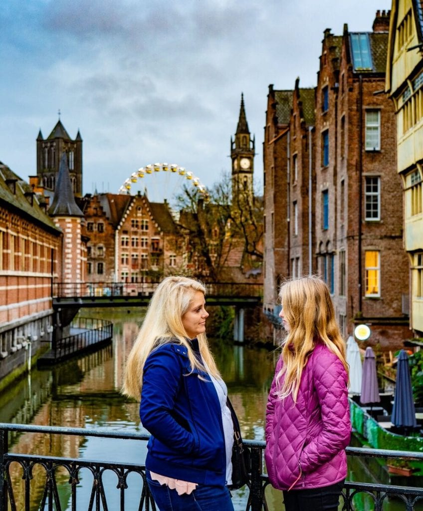 Belgium Trip with Kids: my oldest daughter and I in front of a pretty canal and Ferris wheel