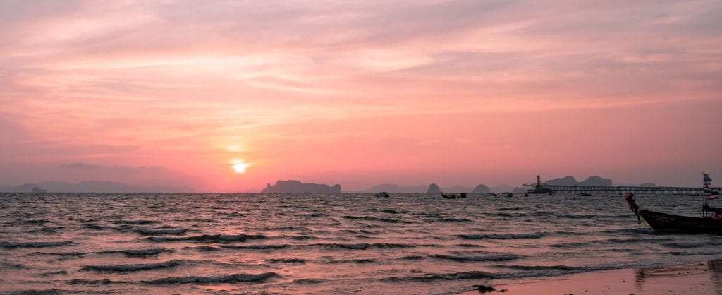 family travel- a beautiful pink sunset over the water