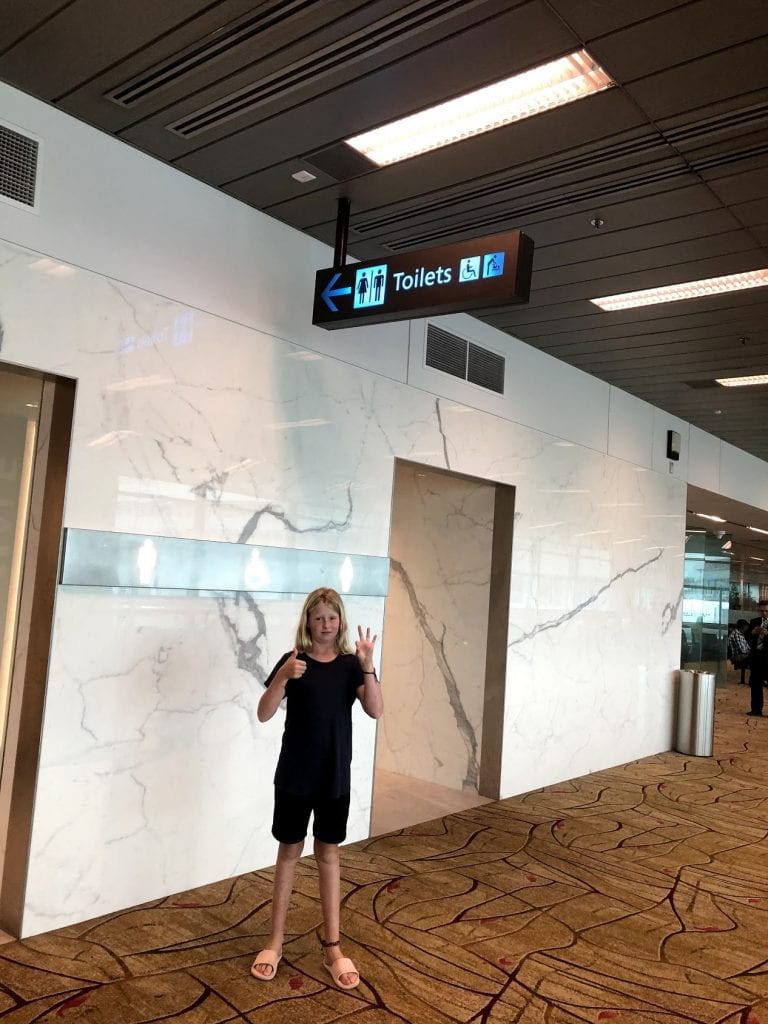 Tips for flying with kids- Lucy outside of the airport restrooms