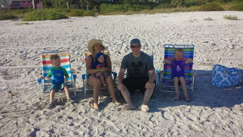 Us and our, then, three kids in lawn chairs on the beach 