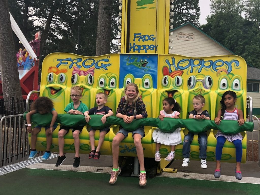 The kids strapped into a rollercoaster called the Frog Hopper