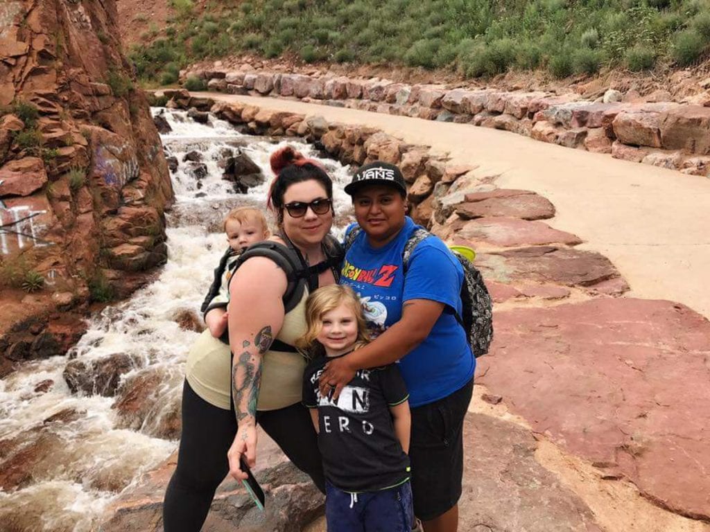 Family picture in front of a stream running through red rock formations