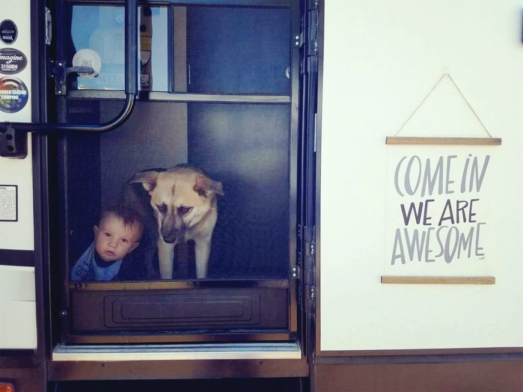 A look inside the trailer with the youngest baby and dog sitting at the door