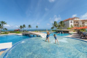 Children playing in the Grand Caribe pool beside the sea in Belize